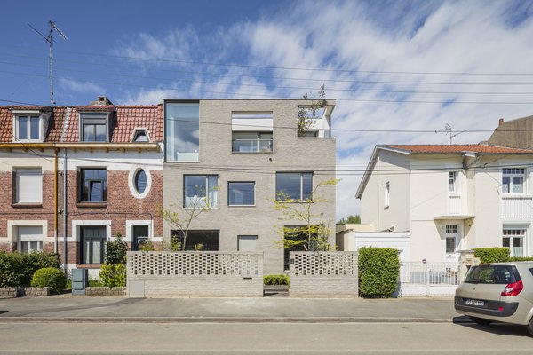 La brique, matériau traditionnel du Nord, est ici revisitée pour donner un accent de modernité au projet. Côté rue, la façade de 9 mètres de long s’habille d’une multitude de menuiseries aluminium Soleal 65. Des grandes fenêtres fixes et des plus petites ouvertures dessinent un jeu de géométrie libre.