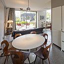 Derrière l’agencement linéaire de la cuisine qui fait office de séparation de pièce, un coin repas a été aménagé.