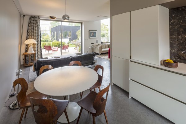 Derrière l’agencement linéaire de la cuisine qui fait office de séparation de pièce, un coin repas a été aménagé.