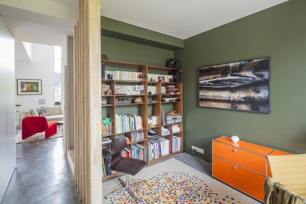 Un mur peint sculpte l’espace dans le coin bibliothèque.
