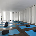Une salle pleine de lumière pour un cours de yoga.