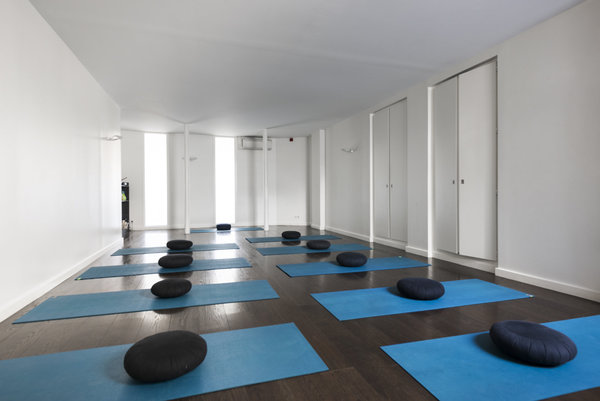 Une salle pleine de lumière pour un cours de yoga.