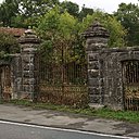 Entrée de propriété avec appareillage en granit et grilles en fer forgé.