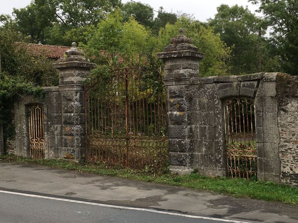 Entrée de propriété avec appareillage en granit et grilles en fer forgé.