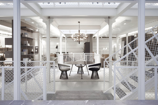 L’escalier métallique immaculé doté de hauts garde-corps qui laisse passer la lumière relie tous les espaces. Au centre, fauteuils en fils d’acier de Warren Platner édités par Knoll et lustre 2097 de Gino Sarfatti édité par Flos.