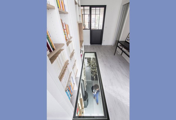 Dans la surélévation, une bibliothèque s’élève sur deux niveaux avec une ouverture dans le plancher intermédiaire, qui permet à la lumière naturelle de circuler.