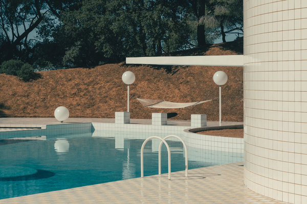 Creusée dans une partie du terrain en pente, la piscine imaginée par Alain Capeillères libère un volume à l’abri des vents, cerné par des murs de soutènement.