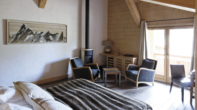 Chambre Deluxe de 45 m² avec coin salon et poêle à bois, salle de bains semi-ouverte, balcon ou terrasse avec vue sur la montagne.