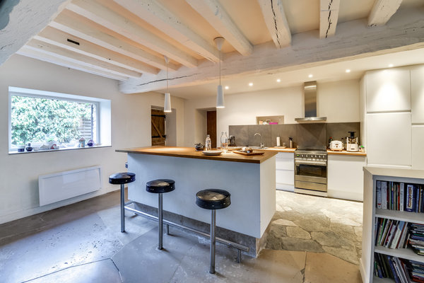 La nouvelle cuisine ouverte très contemporaine avec un sol recouvert de grandes dalles en pierre qui donnent du caractère à l’espace. Chantier confié à l’architecte d’intérieur Thibault de Montmarin pour Rencontreunarchi.