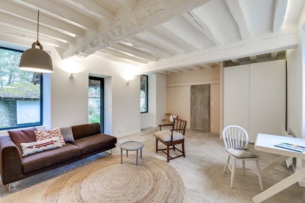 Chaque espace a été repensé. Les clients désiraient des pièces claires et simples. L’architecte Thibault de Montmarin a utilisé très peu de couleurs et de matériaux. Les murs et les poutres sont simplement peints en blanc pour créer une atmosphère très épurée. Et c'est le mobilier qui anime l'espace. Les sols sont différents en fonction des niveaux d’habitation : au rez-de-chaussée on retrouve de grandes dalles de pierre et à l'étage du parquet chêne.