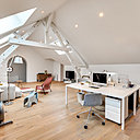 Chaque espace a été repensé. Les clients désiraient des pièces claires et simples.  L’architecte Thibault de Montmarin a utilisé très peu de couleurs et de matériaux. Les murs et les poutres sont simplement peints en blanc pour créer une atmosphère très épurée. Et c'est le mobilier qui anime l'espace. Sous la poutraison repeinte, un grand espace qui profite de belle géométrie de la charpente.