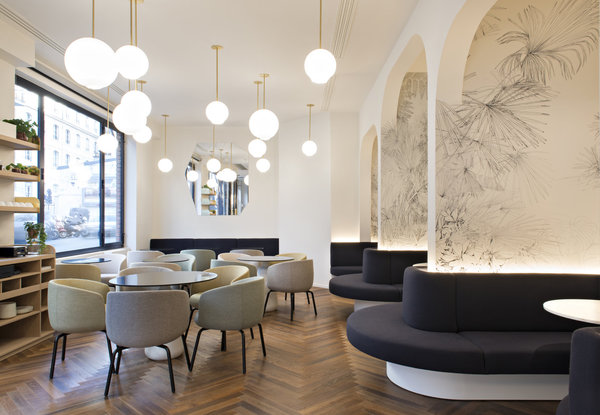 En face des tables, les banquettes gris anthracite dessinent des sortes de cocon. Elles épousent les formes sensuelles de 3 alcôves composant des coins plus intimes. Les murs des 3 niches sont ornées de dessins aux lignes noires très fines, représentant des végétaux, et réalisés par l’artiste Boris Deltchev.