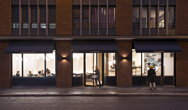 Sur la façade, entre les colonnes de briques rouges du bâtiment, de grandes baies vitrées découvrent une ambiance calme et lumineuse.