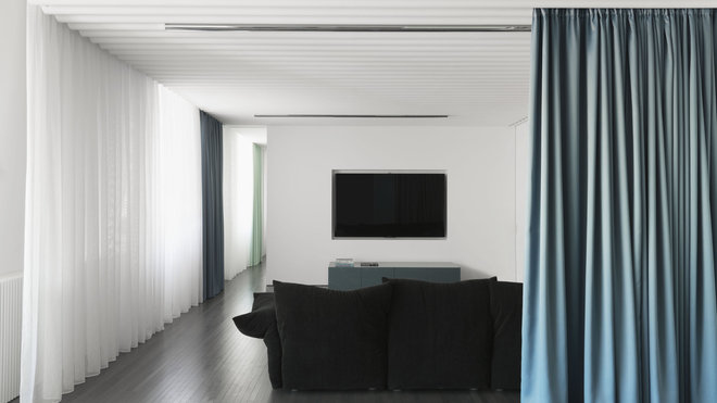 Le home cinéma est caché derrière un rideau textile (Kvadrat). Canapé Essential Sofa de Francesco Binfaré édité par Edra.