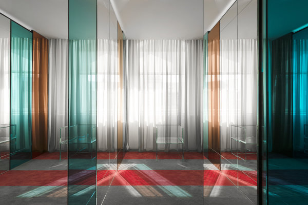 Les miroirs rouge et bleu des chambres et du dressing difractent la minéralité de la résidence, adoucie par le rythme des parois tissées (Kvadrat). Ils jouent avec les bandes colorées de la moquette. Le Fauteuil en verre Prism de Tokujin Yoshokia fabriqué par Glas Italia joue avec les cloisons colorées.
