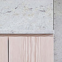 Détail du granit coloris cachemire blanc en association avec le douglas lasuré blanc. Les portes des rangements de la cuisine sont équipées de gorges et prises de main pour offrir des façades discrètes.