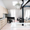 Au niveau du piano, le mur a été recouvert de granit couleur cachemire blanc en continuité avec la crédence et le plan de travail de la cuisine.