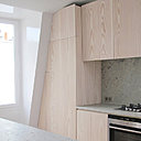 Les meubles de la cuisine sont été réalisés sur mesure pour épouser la pente du toit. Ils renferment et cachent aussi la chaudière.