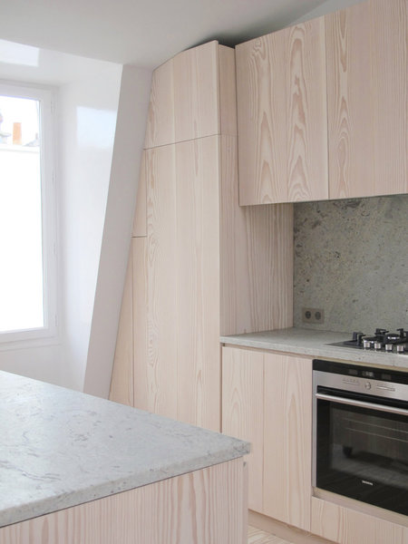 Les meubles de la cuisine sont été réalisés sur mesure pour épouser la pente du toit. Ils renferment et cachent aussi la chaudière.