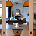 La cuisine est séparée de la salle à manger par une porte coulissante vitrée, intégrée dans le mur de rangement.