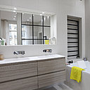 Plan double vasque en Corian, Bains et Déco. Baignoire signée Philippe Starck chez Duravit . Robinetterie, Fantini. Au-dessus de la baignoire, carrelage Folded, création Raw Edges chez Mutina.