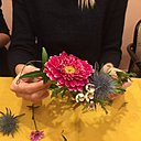 Un mélange de fleurs et végétaux s'imbriquent sur le devant de la couronne.