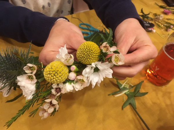 Les fleurs et végétaux se fixent par une simple ligature autour d'une tige de lierre.