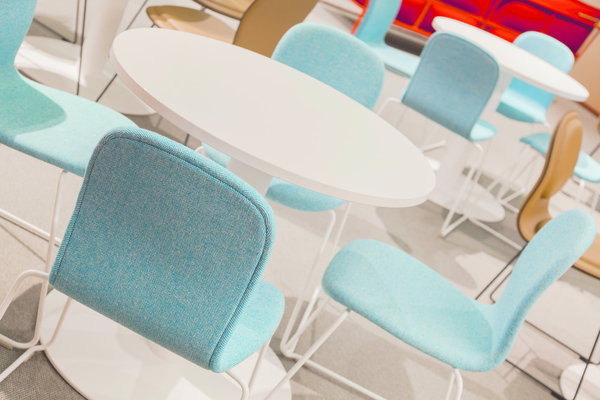 Tables modulaires de la gamme Meeting Collection qui permettent de choisir différentes formes de plateaux et hauteurs, chez Haworth. Chaises Hi Pad, revêtues de tissu. Création Jasper Morison pour Cappellini.