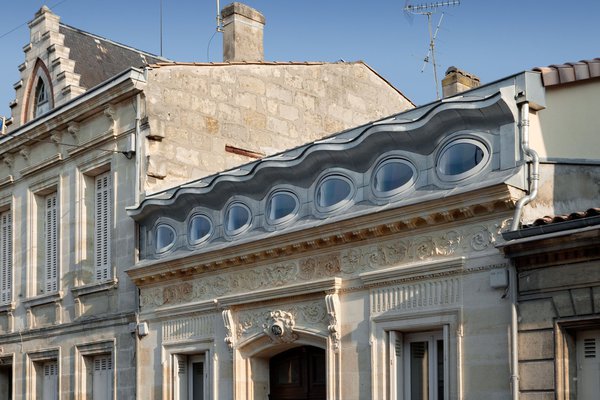Surélévation atypique d’une ancienne échoppe bordelaise qui met en évidence la mariage de la pierre et du zinc naturel pour les lucarnes, création de l’architecte  Bernard Nivelle.
