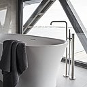 Nappée d’un dallage de pierre naturelle, la salle de bains est dotée d’une baignoire en îlot, se reflétant dans un miroir, Elle offre un mur entièrement vitré sur le port.