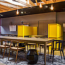 Du noir et jaune, dans la cafétéria, pour s’associer au bois clair des meubles et un tapis de carrelages effet patchwork en carreaux de ciment.