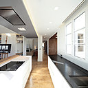 La pièce à vivre en enfilade est rythmée par les meubles qui délimitent les différents espaces et leur fonction respective.