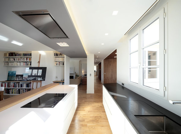 La pièce à vivre en enfilade est rythmée par les meubles qui délimitent les différents espaces et leur fonction respective.