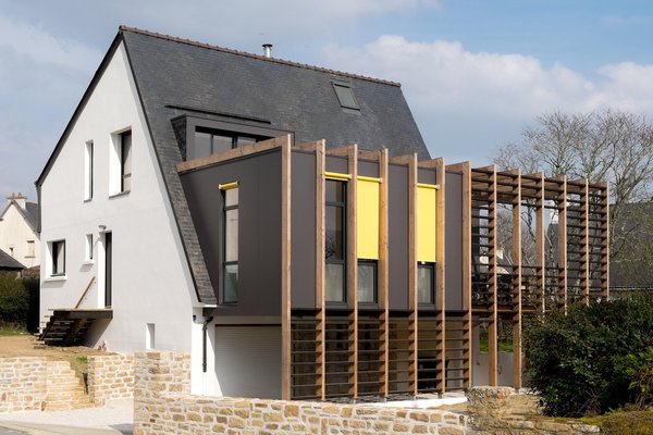 Une partie du terrain a été aplanie pour créer un vrai espace utilisable. La terrasse construite de plain-pied avec le rez-de-chaussée est protégée de la rue par le volume d’extension.