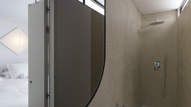 Derrière des placards muraux, une douche à l’italienne à fleur de sol pour la chambre 12 imaginée par Valentina Cameranesi et Enrico Pompili.