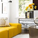 Aux côtés du canapé Tufty-Time’15 créée par Patricia Urquiola et édité par B and B Italia choisi dans une teinte jaune éclatante, buffet Wrongwoods de Richard Woods et Sébastien Wrong, édité par Established ans Sons offrant un effet trompe-l’œil d’un veinage de bois.