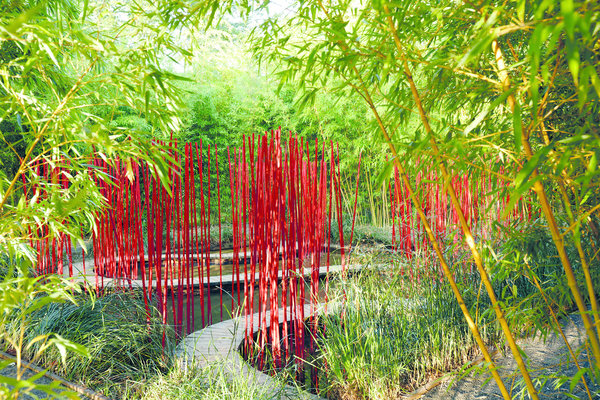 Jardin chinois du grand paysagiste Yu Kokgjian qui dessine un souple ruban de bambous rouges qui jouent avec le ciel et l’eau. Création « Carré et rond », 2017.