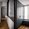 Priorité aux rangements avec deux grands dressings et une zone de placards bas dans le couloir qui cache notamment le lave-linge sous les fenêtres intérieures de la salle de bains travaillées en claustra.