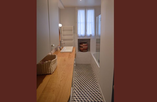 La forme en couloir de la salle de bains a été exploitée pour aménager un long meuble de rangement.