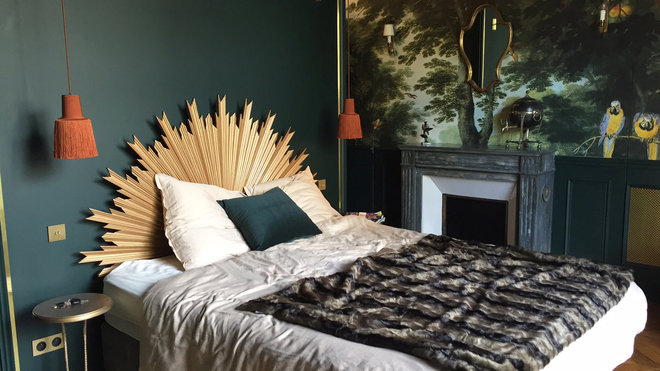 La tête de lit façon écran et tableau occulte la salle de bains.