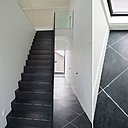 Les zones de circulation ont été traitées pierre naturelle sombre. La pose en diagonale agrandit le couloir.
