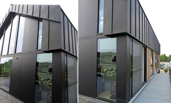 La maison est revêtue de panneaux en acier peint en noir ponctué de bois qui brise son côté métallique.