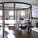 Comme un manège, table circulaire Swing, avec chaises suspendues à un cadre de baldaquin pour un design ludique.  Création Duffy London.
