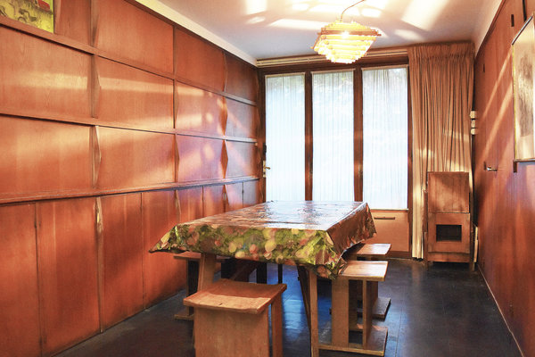 La salle à manger de l’appartement situé au second niveau offre des rangements muraux intégrés avec un mobilier d’origine en adéquation.