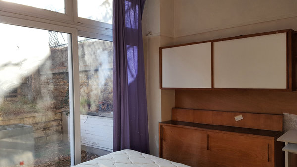 La chambre d’un des deux studios du rez-de-chaussée qui donne sur la cour arrière est dotée d’un rangement intégré avec portes coulissantes.