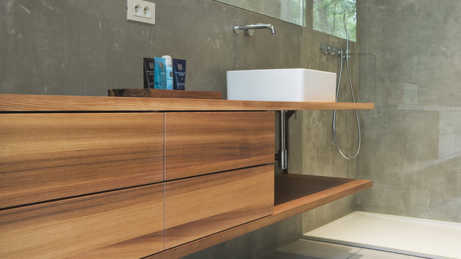 Douche à l’italienne et long meuble vasque intégré qui fait gagner de la place dans la salle de bains.