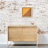 Buffet Monolit deux portes en chêne clair enchâssé dans un cadre en métal fin et peint en blanc, 3 finitions possibles. Création Ethnicraft.