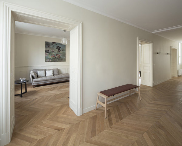 Côté cuisine, salle à manger ou salon, le sol est unifié par un parquet neuf à chevrons.  Banc, modèle Imo, chez Pinch. Au mur, appliques, modèle Diamante chez Vistosi.