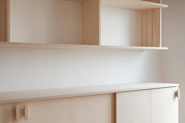 Le caractère discret du mobilier laisse des possibilités d’appropriation aux futurs occupants. Il permet ainsi de créer une intimité tout en décorant l’espace à la manière des anciennes demeures. Ici, ce meuble deux corps, accroché au mur, offre une interprétation contemporaine du buffet traditionnel de salle à manger ou de salon.