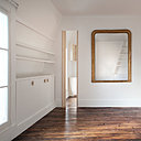 Au sol, l’implantation perpendiculaire aux fenêtres du nouveau parquet de couleur claire contraste subtilement avec le parquet existant rénové. Les ouvertures ont été valorisées avec de larges portes en bois clair.